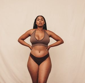 Self-confident young woman standing in brown underwear